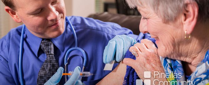 Doctor administers vaccine shot to elderly woman.