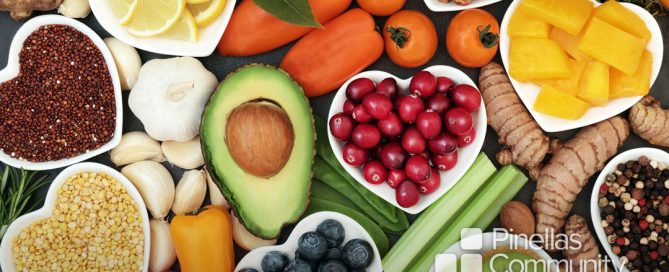 Fruits, vegetables laid out on counter top, heart shaped bowls.