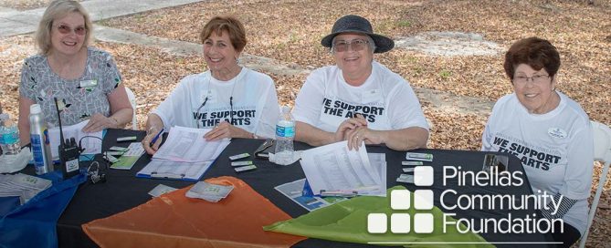 Happy, smiling volunteers at Festivale 50 registration table