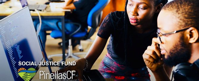 A Black woman and man work together on a computer.