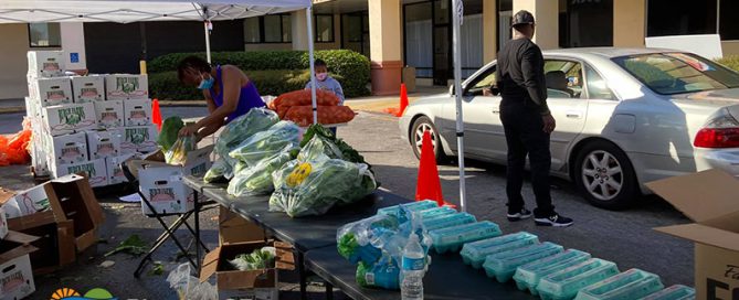 Advantage Village Academy workers load groceries in trunks at the drive-thru pantry.