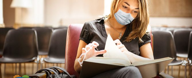 A college student wearing a mask studies law in the library.