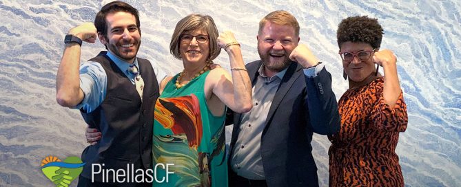 PCF staff members David Bender, Leah Slavensky, Duggan Cooley, and Leigh Davis flex their biceps in front of a painting at Leah's retirement party in Creative Pinellas, Largo.
