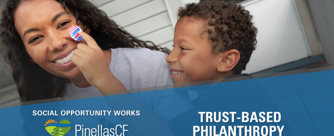 Boy puts I voted early sticker on young mother's face while sitting on their front porch.