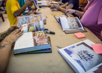 Side perspective of volunteers reviewing mural magazines.
