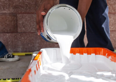 Closeup of painting being poured into a pan.
